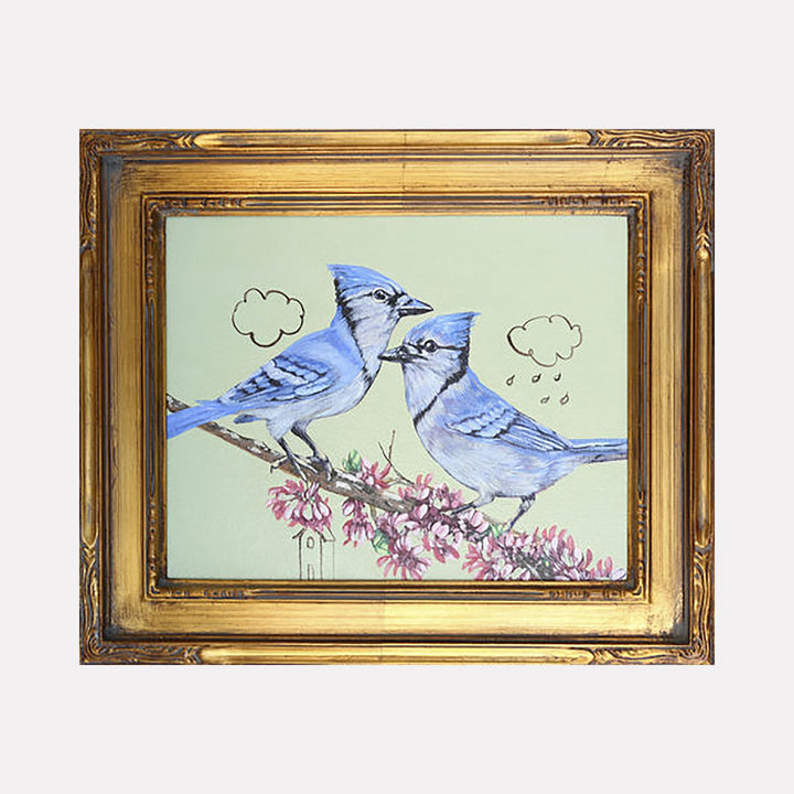 The artwork "Planning for the Future" by Carlos Gamez de Francisco features two detailed blue jays perched on a blossoming branch against a muted green background, with simple line-drawn clouds above them. The piece combines delicate textures and soft pastel colors, framed in an ornate golden frame, evoking themes of nature and hope.