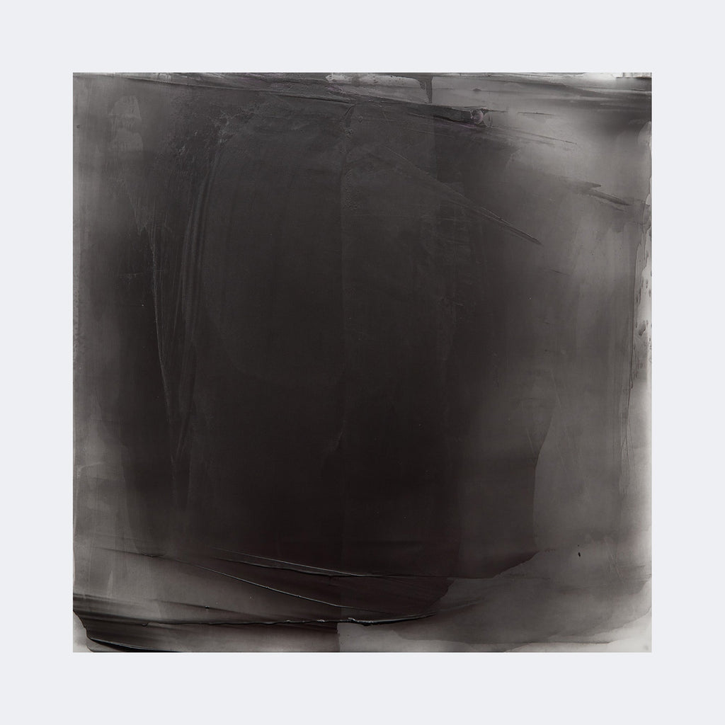 The artwork "Graphite Veil 11" by Debra Ramsay features a large square composition dominated by deep graphite gray tones, layered with soft gradients and subtle textures that evoke a misty, ethereal veil. The abstract style and monochromatic palette recall the minimalist tonal explorations of artists like Mark Rothko and Agnes Martin.