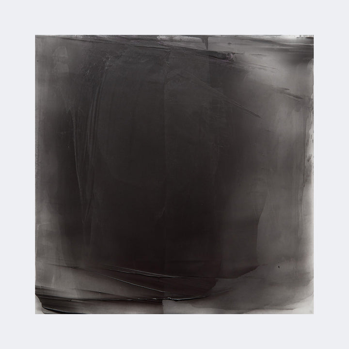 The artwork "Graphite Veil 11" by Debra Ramsay features a large square composition dominated by deep graphite gray tones, layered with soft gradients and subtle textures that evoke a misty, ethereal veil. The abstract style and monochromatic palette recall the minimalist tonal explorations of artists like Mark Rothko and Agnes Martin.