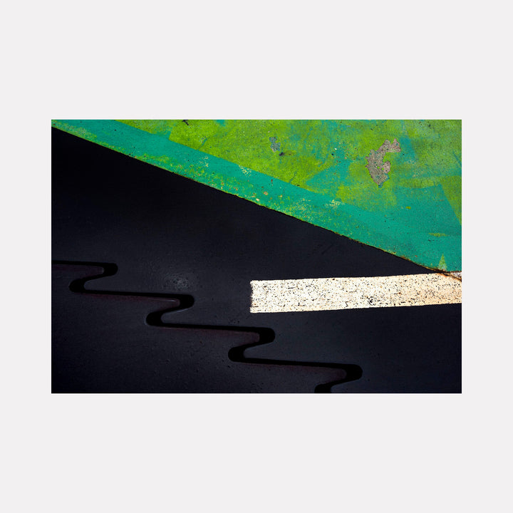 Road Paint 01 by Steve Edson features a striking abstract composition with a textured green diagonal section contrasting against a smooth black background. A bold white horizontal stripe intersects dark curving lines, evoking a graphic, modern interpretation of urban road markings with a sharp, minimal aesthetic.