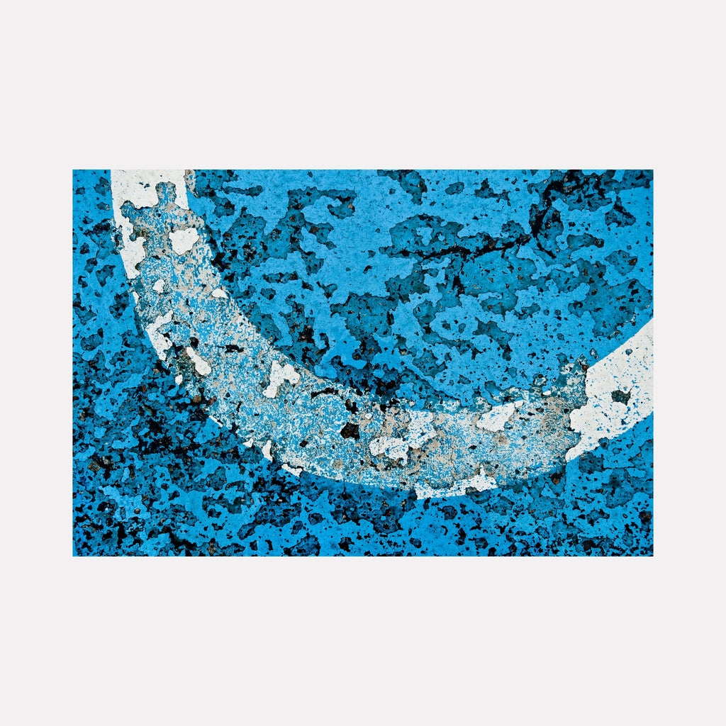 Road Paint 03 by Steve Edson features a textured abstract design with a distressed white curved line set against a vivid, cracked blue surface, evoking an urban, weathered aesthetic that combines raw texture and bold color contrasts in a contemporary artistic style.