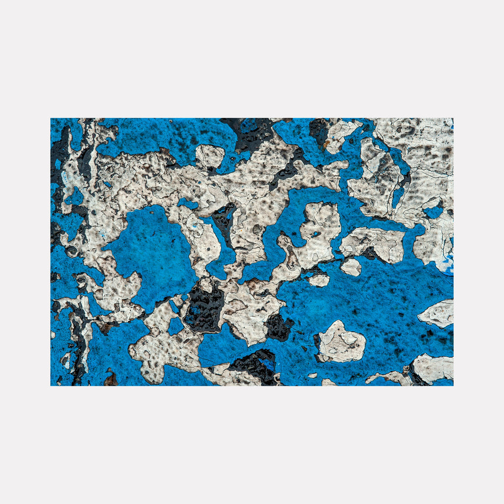 Road Paint 05 by Steve Edson captures a dynamic abstract pattern with peeling white and black paint over a vibrant blue textured surface, evoking the raw, weathered look of urban decay combined with organic, irregular shapes creating a visually compelling, contemporary composition.