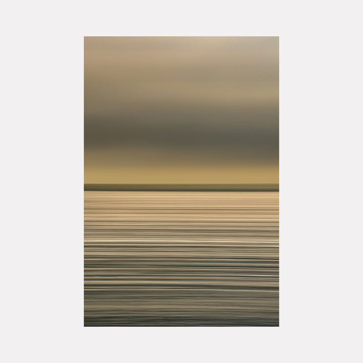 The artwork "Sun Streaks On The Atlantic" by Neil Shapiro features a minimalist seascape with layered horizontal lines in muted gold, gray, and soft beige tones. The subtle gradation and textured brushstrokes evoke the serene atmosphere and calm motion of the Atlantic, reminiscent of Mark Rothko’s color field and Agnes Martin’s restrained, meditative abstraction.