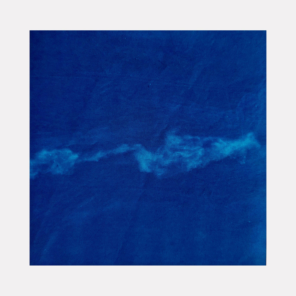 The artwork "Sea 1" by Starr Tucker-Ortega features a deep blue textured background with a flowing, cloud-like white streak running horizontally through the center, evoking the calm and movement of ocean waves. The abstract style and rich color palette emphasize depth and tranquility. Starr Tucker-Ortega.