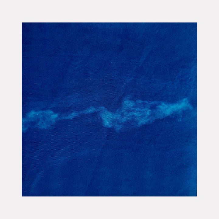 The artwork "Sea 1" by Starr Tucker-Ortega features a deep blue textured background with a flowing, cloud-like white streak running horizontally through the center, evoking the calm and movement of ocean waves. The abstract style and rich color palette emphasize depth and tranquility. Starr Tucker-Ortega.