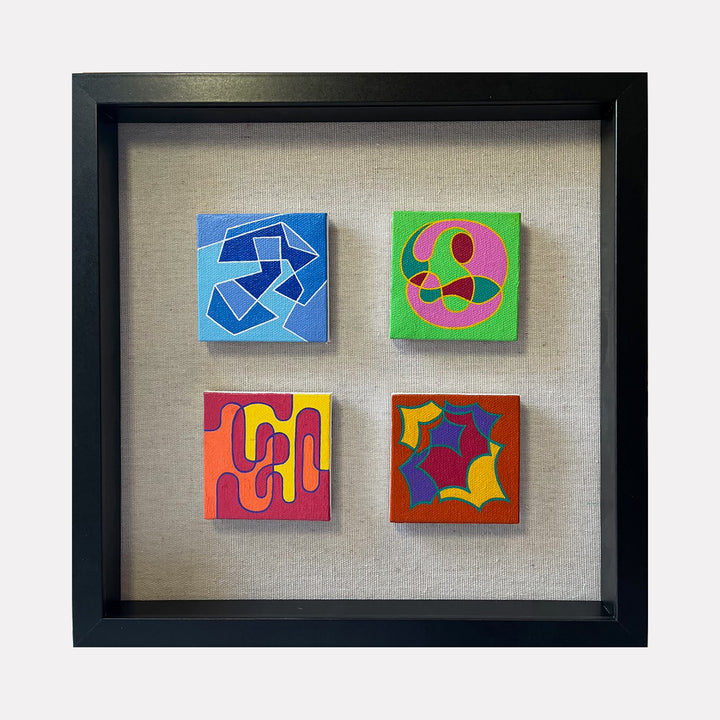 The artwork "Seasonal Phenomena IV" by Joe Piscopia features four small framed acrylic paintings on canvas with abstract geometric shapes in vivid colors including blue, green, red, yellow, pink, and purple. Each piece displays distinct textured patterns and modern design elements in a 13x13 inch framed composition. Joe Piscopia