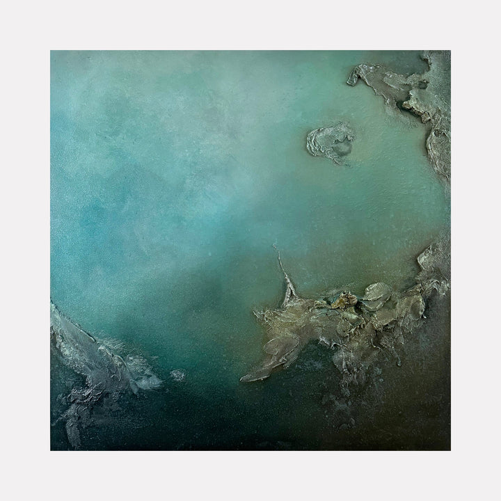 The artwork "A Ways Away" by Abbey Stace features a textured abstract in deep aquamarine and muted teal, with rugged, organic forms in earthy grey and brown tones suggesting rocky outcrops submerged in water. The layered surface evokes a quiet, meditative mood reminiscent of Anselm Kiefer’s materiality and the serene abstractions of Agnes Martin.