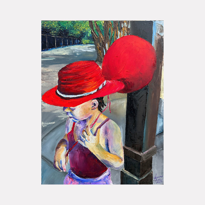 The artwork "The Balloon's Keeper" depicts a child in a red hat and maroon top holding a large red balloon tied to a dark post on a sunlit sidewalk with trees in the background. The painting features vivid colors, textured brushstrokes, and an impressionistic style. By Lauren Luna.
