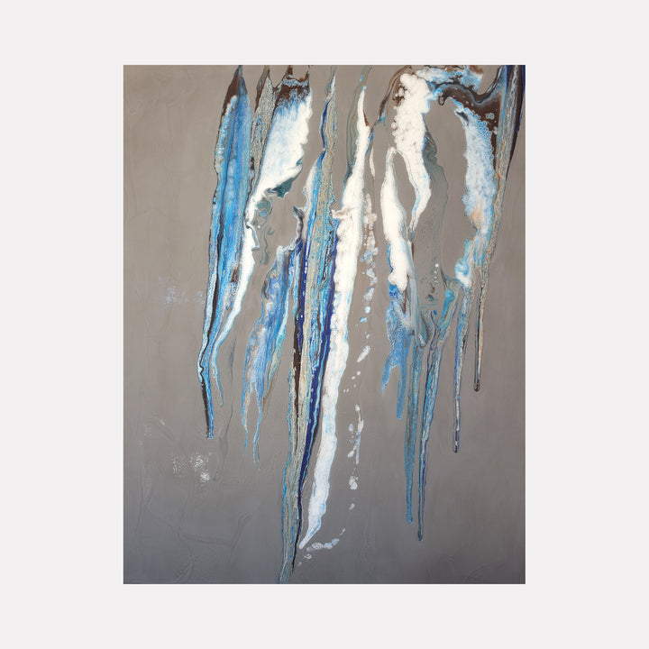 The Wind of Blue by Swann Freslon presents elongated, flowing streaks of blue, white, and gray tones cascading against a muted taupe background, evoking a serene, atmospheric movement reminiscent of gentle winds or cascading water in a refined contemporary abstract style.