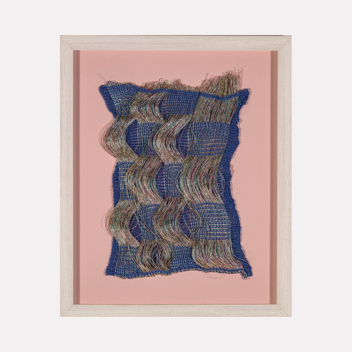 Time Streams (#1) by Craftwork presents a woven textile art piece with undulating multicolored threads set against a deep blue base, framed in light wood and mounted on a soft pink background, blending tactile texture with fluid motion in a contemporary art style.