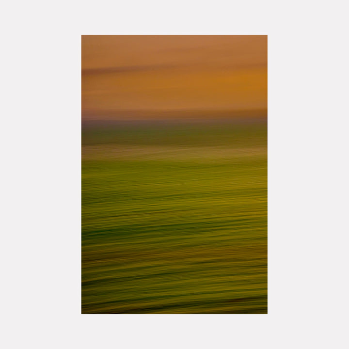The artwork "Uncharted Ocean" by Neil Shapiro features a horizontal abstract composition with blurred bands of green and gold tones blending into warm amber and brown hues. The soft, flowing textures evoke a sense of motion and depth, reminiscent of Mark Rothko’s color fields and Helen Frankenthaler’s atmospheric washes.
