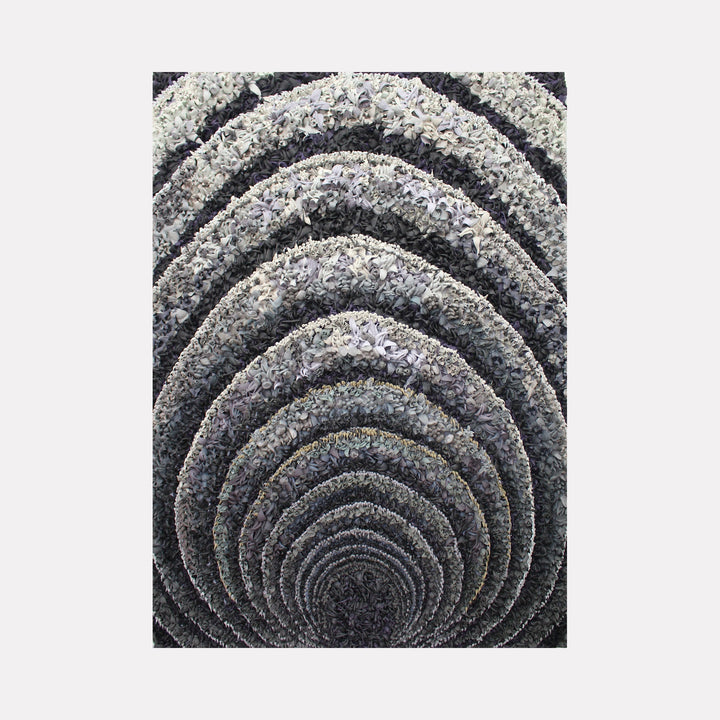 The artwork "Vortex" by Seren Morey features concentric, textured arches layered in shades of gray, black, and white, creating a hypnotic tunnel effect. The intricate, organic patterns and monochromatic palette evoke the abstract style of Bridget Riley and the optical illusions found in M.C. Escher’s work, inviting deep visual contemplation.