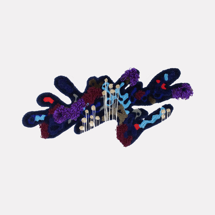 The artwork "Vulturine Guinea Fowl Hen" by Abigail Henthorne presents a complex abstract form with textured, plush surfaces in deep blues, purples, maroons, and accents of bright red and pale blue. The organic, flowing shapes combined with woven and tufted fibers evoke the expressive, biomorphic abstractions of Jean Dubuffet and the rich, tactile detail reminiscent of Louise Bourgeois’ textile sculptures.