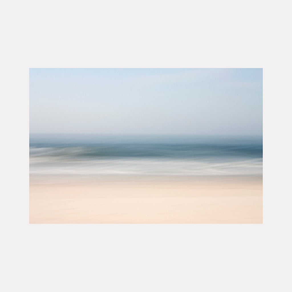 The artwork "A Summer Day" by Sandi Daniel features a serene abstract landscape with soft, blurred layers of pale sandy beige, muted blues, and gentle grays. The smooth transitions and minimalist composition evoke a tranquil coastal atmosphere, reminiscent of the subtle color fields by Mark Rothko and the ethereal seascapes of Hiroshi Sugimoto.