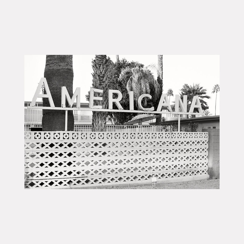 Americana by Esther Voisin: Vintage Americana sign in black and white film, geometric breeze block wall, palm trees silhouetted against sky