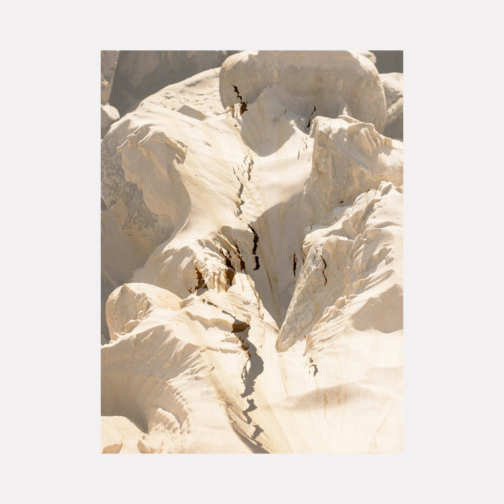 The artwork "erosion" by Eunice Pais captures a close-up of weathered rock formations bathed in soft beige and cream tones, emphasizing natural cracks and layered textures. The organic shapes and subtle shadows evoke the tactile geological aesthetics found in the works of Richard Long and the contemplative naturalism of Andy Goldsworthy.