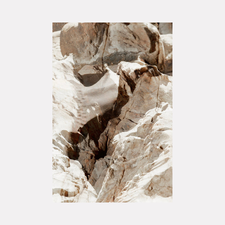 The artwork "erosion 9" by Eunice Pais captures a close-up view of weathered rock formations in soft beige and cream hues. The composition highlights intricate fractures and layered textures, evoking the serene geological studies of Richard Long and the contemplative natural forms found in Andy Goldsworthy’s art.