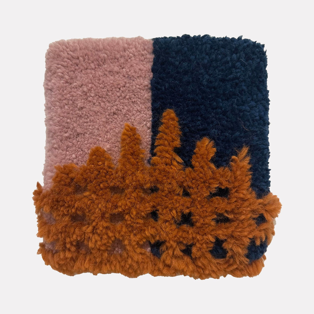 The artwork "Growth" by Ana Maria Farina features a textured, tufted design with a soft pink section on the left, a deep navy blue section on the right, and a raised, organic, burnt orange pattern overlaying the bottom half, creating a dynamic contrast of colors and tactile fibers.