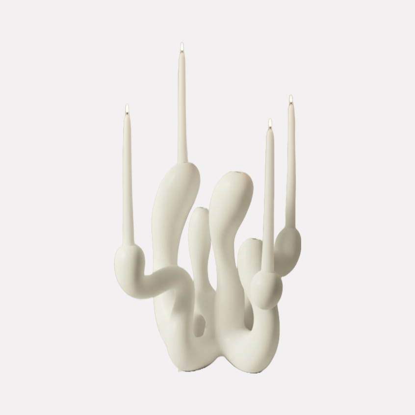 Hold the Light Sculptural Candleholder (White) by Shadia Sabagh features an organic, flowing form crafted in smooth white material, holding multiple slim white taper candles. The design blends modern artistry with functional elegance, creating a striking sculptural centerpiece with a minimalist yet dynamic presence.