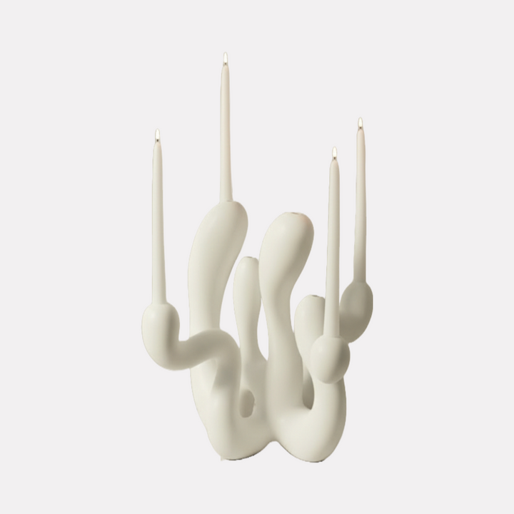 Hold the Light Sculptural Candleholder (White) by Shadia Sabagh features an organic, flowing form crafted in smooth white material, holding multiple slim white taper candles. The design blends modern artistry with functional elegance, creating a striking sculptural centerpiece with a minimalist yet dynamic presence.