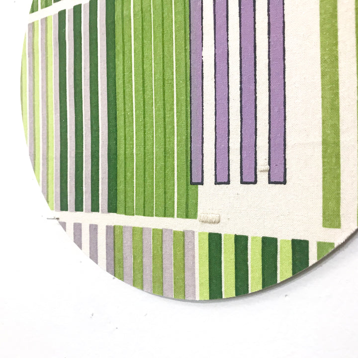Line Study 1 by Molly Koehn features vertical stripes in varying shades of green and lavender on raw silk, creating a modern geometric composition. The parallel lines alternate in width and color intensity, mounted on circular birch panel. The minimalist design combines pigment and embroidery techniques.