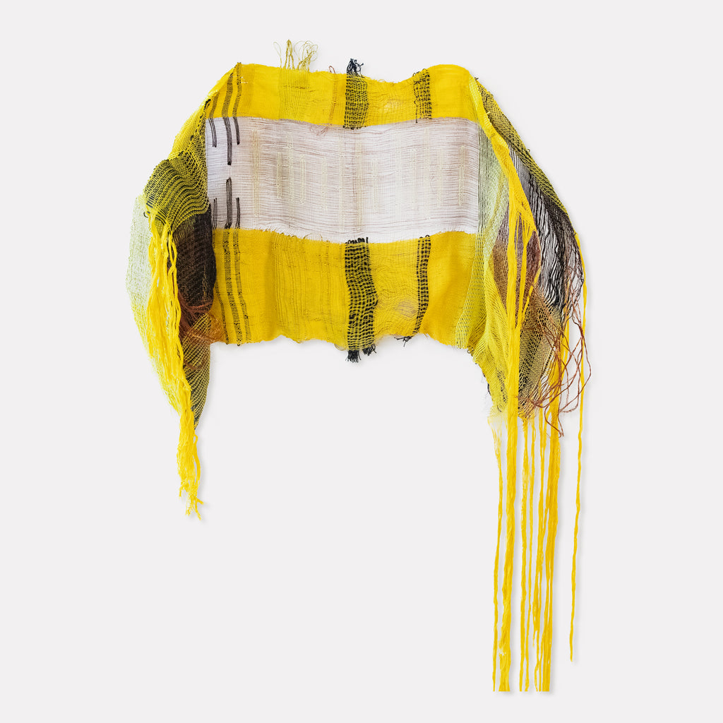 The artwork 'Entrance, English Morse Code' by Kathie Halfin features a striking textile composition with vibrant yellow and white horizontal stripes. The woven piece incorporates cotton, copper wire, and flux yarn, creating an abstract pattern with dangling threads and textural elements. The piece measures 72 inches in height and 17 inches in width, displaying a contemporary artistic interpretation of textile craft. By Kathie Halfin.