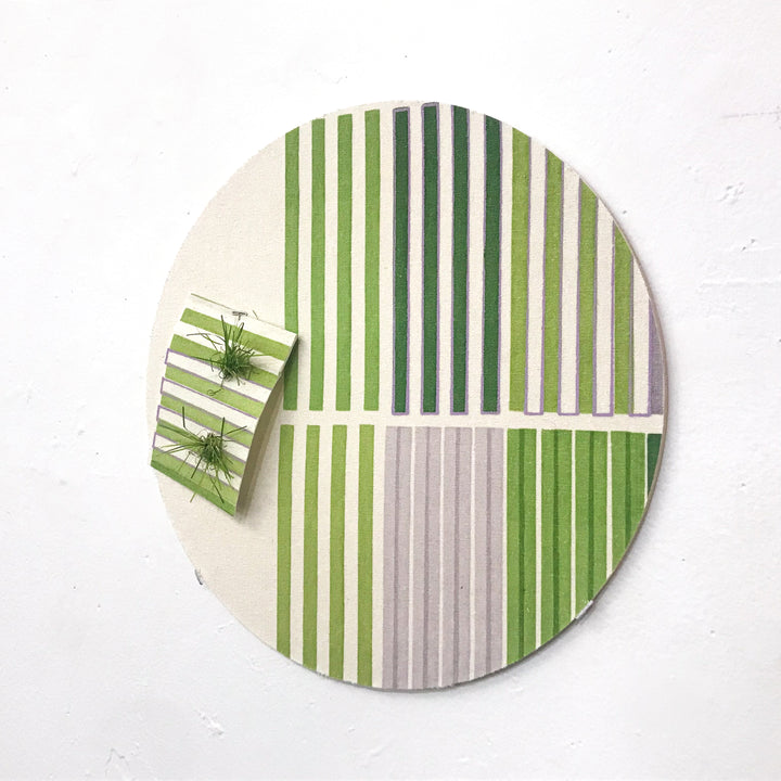 The artwork 'Line Study 4' by Molly Koehn features a circular composition with vertical green and white stripes in varying widths. A small matching rectangular piece protrudes from the main circle, creating visual interest. The piece combines astroturf and pigment on raw silk, mounted on birch, showcasing a geometric pattern with a modern, minimalist aesthetic.