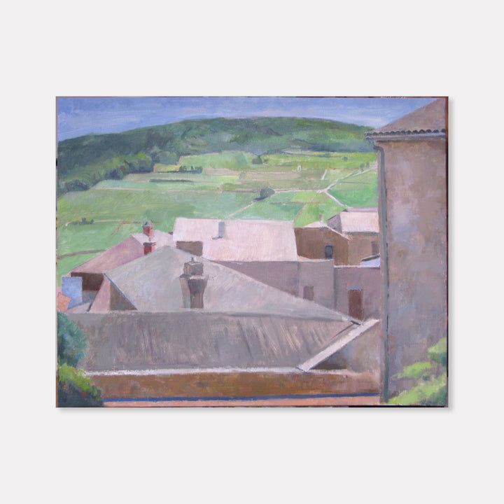 The artwork 'Solutré-Pouilly' by Peter Colquhoun depicts a serene rural landscape with terracotta-roofed buildings nestled against rolling green hills. The composition features muted pink and gray buildings in the foreground, with verdant vineyard-striped slopes in the background under a soft blue sky. Oil on linen captures the tranquil Mediterranean atmosphere.