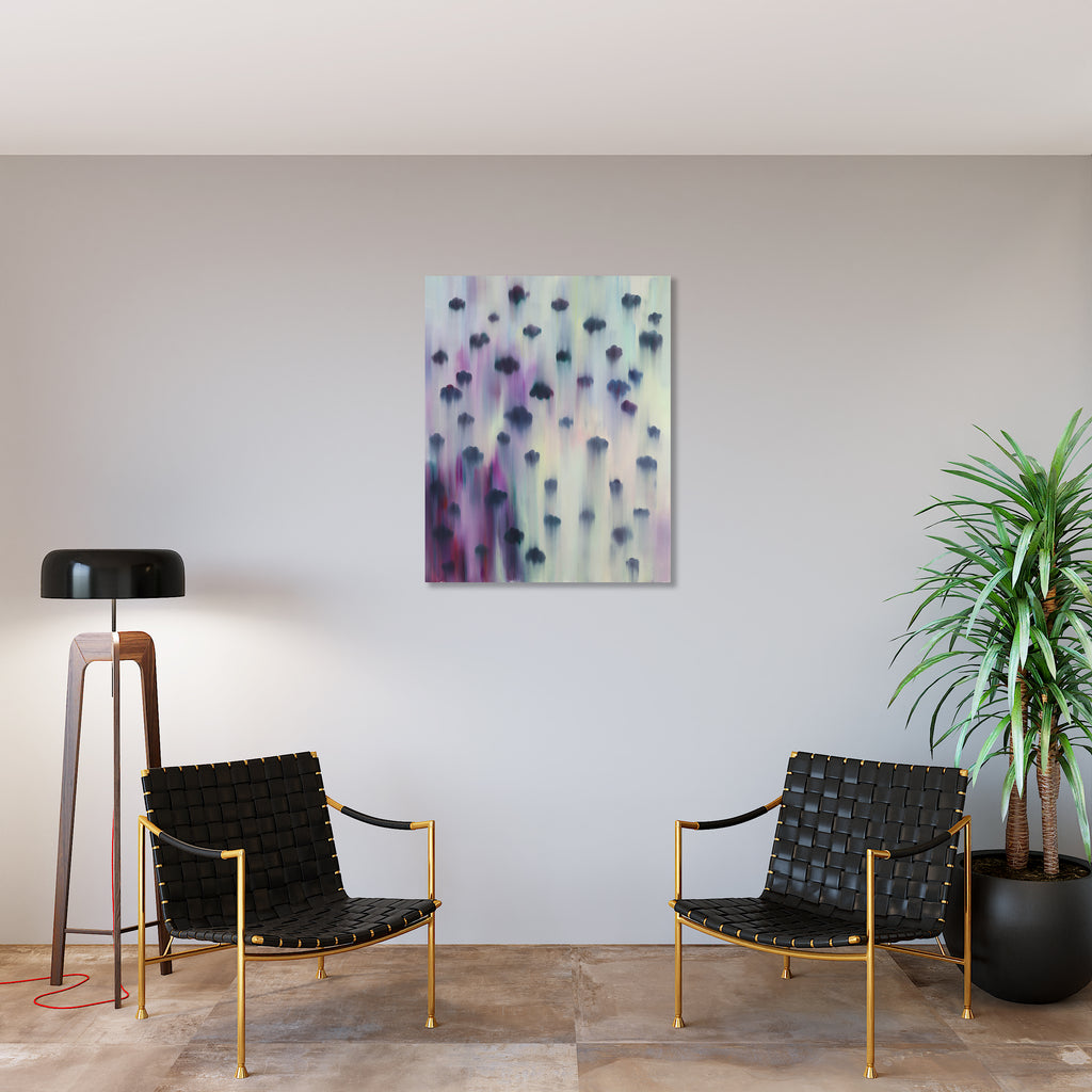 The artwork 'Cloud Busting' by Ketta Ioannidou features ethereal dark clouds floating against a dreamy backdrop of soft purples, blues, and cream. The clouds appear to be falling or floating downward, creating a sense of movement through blurred brushstrokes in oil paint, evoking a mystical atmospheric effect on canvas.