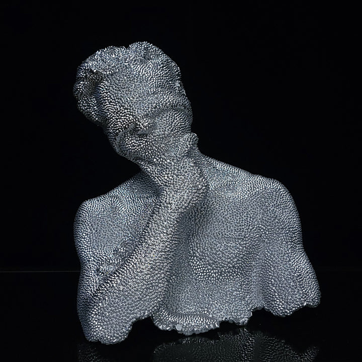 The artwork 'Thinking Blind - Original' by IvIvI features a metallic silver resin sculpture against a black background. The textured bust depicts a figure in contemplative pose, with a distinctive stippled surface pattern creating a mesmerizing visual effect. The 10-inch sculpture showcases intricate detailing in a contemporary minimalist style.