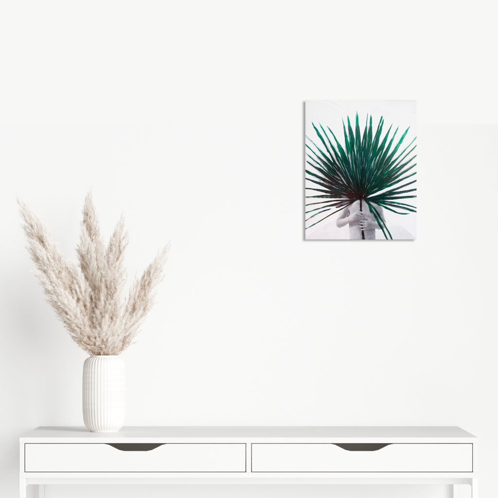 The artwork 'Palm Child' by Aaron Hillebrand features a vibrant emerald green palm frond emerging from a minimalist grey background, created through acrylic paint and photo transfer on wood panel. The dramatic fan-like leaves spread outward in sharp detail, contrasting against the soft neutral backdrop, measuring 10x8 inches by Aaron Hillebrand.