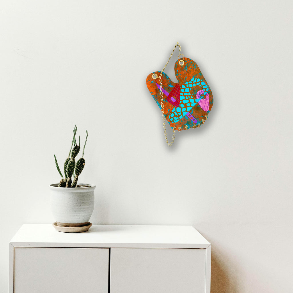 The artwork 'Bunny' features a whimsical abstract design on paper, combining vibrant turquoise mosaic patterns with rust-colored textures. Pink and purple accents create playful shapes, while metallic chain elements and yellow triangular details add dimensional interest. The acrylic painting blends geometric and organic forms in a contemporary style. By Sunny Chapman.