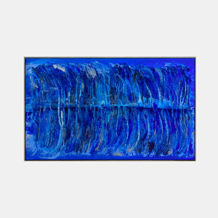 The artwork 'The Water's Edge by Moonlight' by Camilla Webster features dramatic vertical brushstrokes in varying shades of deep cobalt and cerulean blue, creating a mirror-like reflection effect. The textured acrylic on canvas suggests rippling water illuminated by moonlight, with subtle silvery highlights and darker navy undertones throughout the 37x61 inch composition.