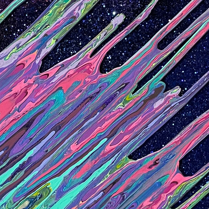 The artwork 'Galaxy Kinetic e-' by Paola Gracey features dynamic diagonal streaks of iridescent colors flowing across a starry black background. Swirling patterns of pink, turquoise, purple, and green create a fluid, cosmic effect enhanced by glitter and resin. The marbled texture resembles an ethereal aurora borealis or celestial energy streams in motion.