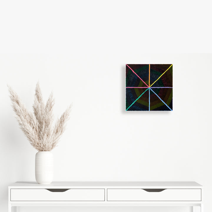 The artwork 'Chromatic' by Amber Heaton features a striking geometric composition with vibrant rainbow-colored lines intersecting to form a starburst pattern on a black background. The 12x12 inch acrylic painting on panel creates a dynamic radial design, with lines emanating from the center in eight directions, showcasing a spectrum of blues, pinks, yellows, and greens.