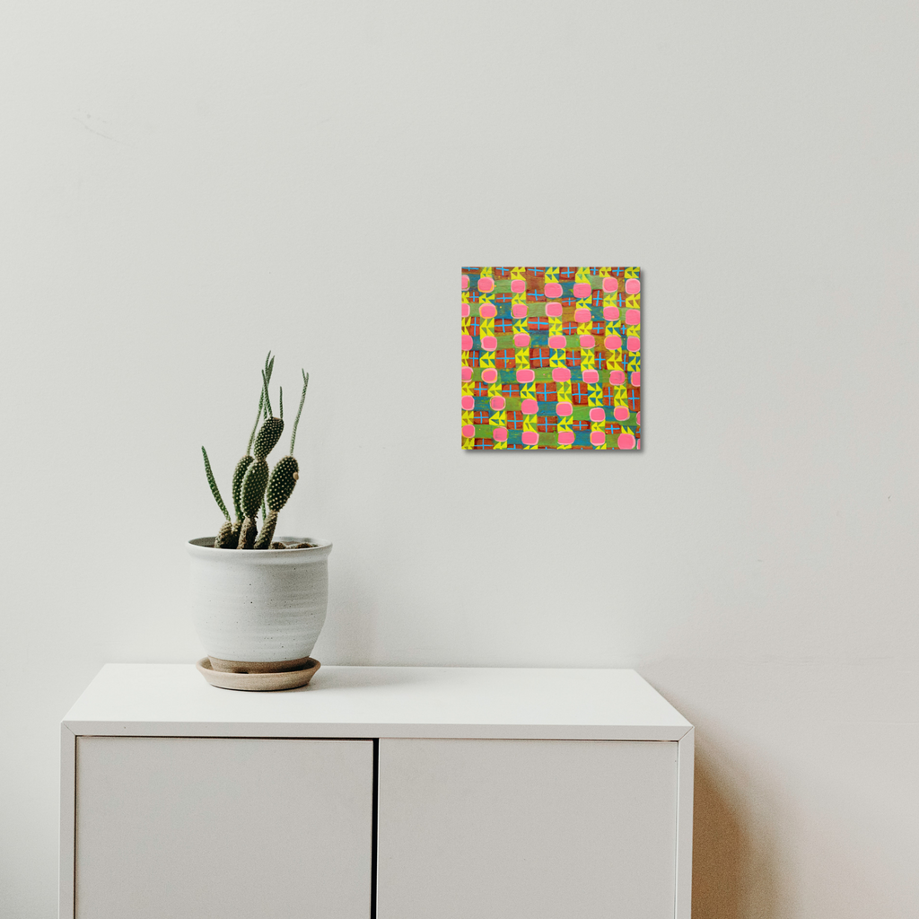 The artwork 'Composition No. 239' by Raul Ortiz features a vibrant grid pattern with interwoven pink, yellow, and green geometric shapes on linen canvas. The abstract composition creates a dynamic interplay of colors and rectangular forms. A 12x12 inch acrylic painting mounted above white furniture with minimalist styling. - By Raul Ortiz