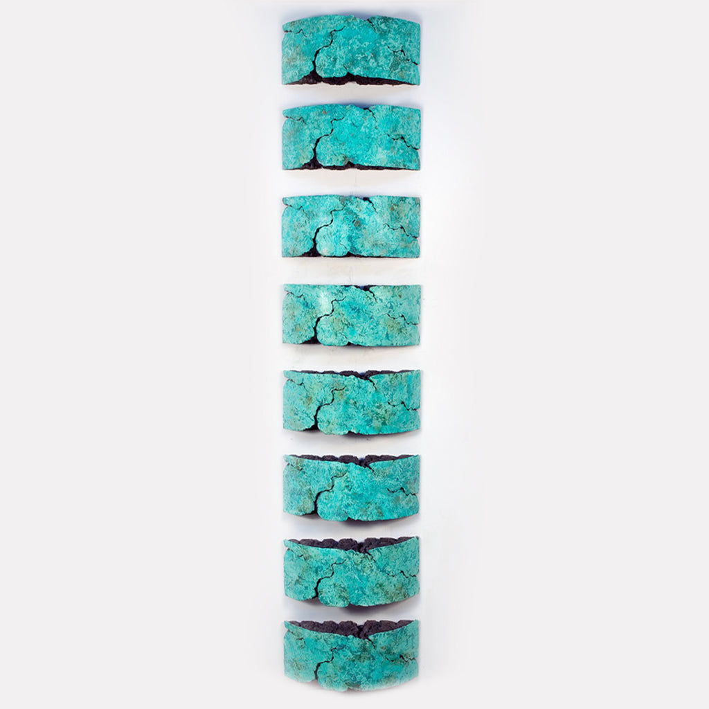The artwork 'CONNECTED lll' by Nora Chavooshian features eight vertical segments of turquoise-colored sculptural elements with a weathered, crackled texture. Each segment displays a rich patina reminiscent of natural turquoise stone, arranged in a linear column against a white background. The bronze patina creates organic patterns and fissures across each cast forton piece.