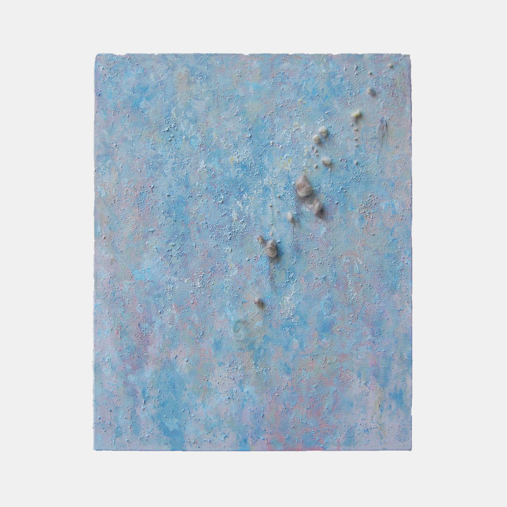 The artwork 'Eruption' by Noriko Okada features a textured abstract composition in ethereal light blue and gray tones, with raised elements suggesting volcanic activity. The mixed-media piece combines oil paint and yarn creating a dimensional surface with scattered darker spots emerging from a misty, atmospheric background, measuring 30 x 24 inches.