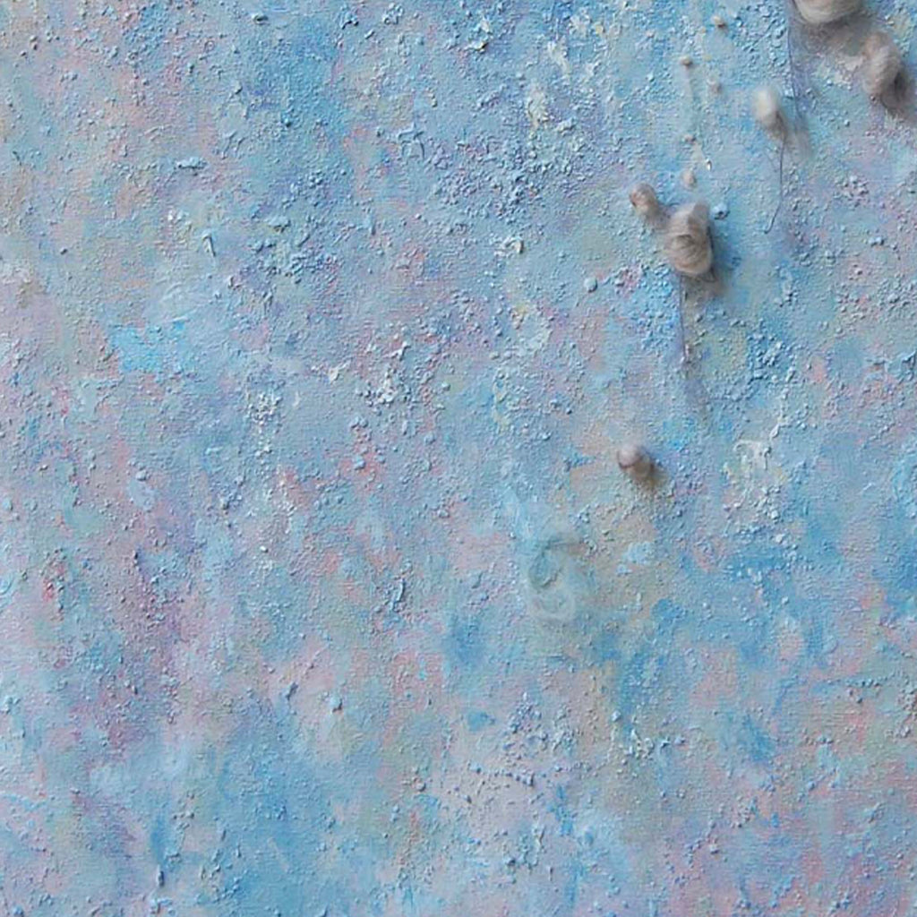 The artwork 'Eruption' by Noriko Okada features a textured abstract composition with ethereal blue and pink hues blending across the canvas. Raised circular elements create a dimensional effect, while yarn details add organic texture. The surface resembles a celestial landscape with its dreamy pastel color palette and tactile, crater-like formations.