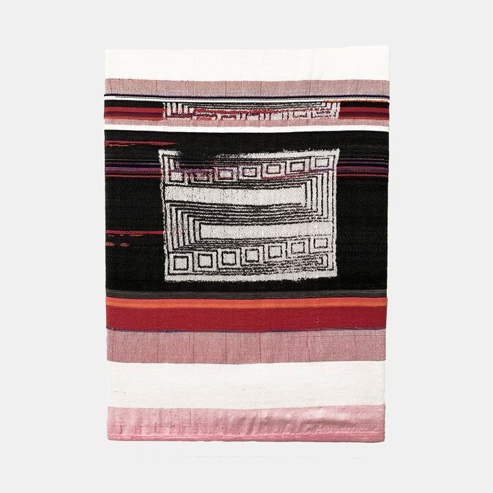 The artwork 'Floating Maize Processor' by Robin Kang features a geometric abstract design with layered horizontal stripes in black, pink, and red. A central white rectangular pattern with maze-like squares and linear elements contrasts against a dark background. Hand jacquard woven cotton and hand-dyed wool create textural depth through traditional weaving techniques.
