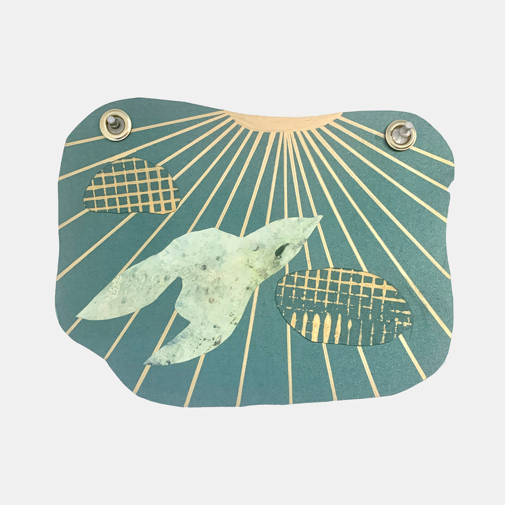 The artwork 'Fly to the Sun' by Sunny Chapman features a delicate bird silhouette in pale mint green soaring through radiating golden sunbeams on a teal background. Abstract grid patterns float alongside the bird, while silver grommets anchor the corners of this mixed-media collage on metallic paper, creating a modern, geometric composition.