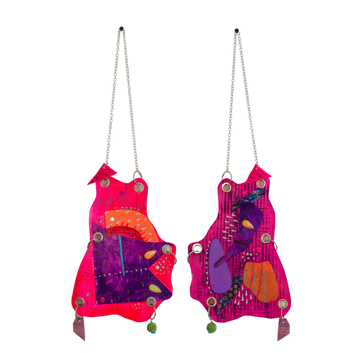 The artwork 'Frog Mouth' by Sunny Chapman features dual hanging pieces with vibrant pink, purple, and orange abstract shapes adorned with metallic chains. Each piece displays whimsical organic forms embellished with grommets, glitter, and decorative jewels, creating a symmetrical mixed-media composition with playful textures and dimensional elements. By Sunny Chapman.
