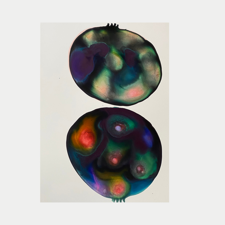 The artwork 'Galactic Pomegranate' by Arielle Stein features two abstract pomegranate forms rendered in vibrant ink on paper. The organic shapes display swirling nebula-like patterns in deep blues, purples, teals, and luminous reds. The celestial-inspired piece combines fluid watercolor techniques with bold cosmic colors, creating an otherworldly interpretation of the fruit's internal chambers.