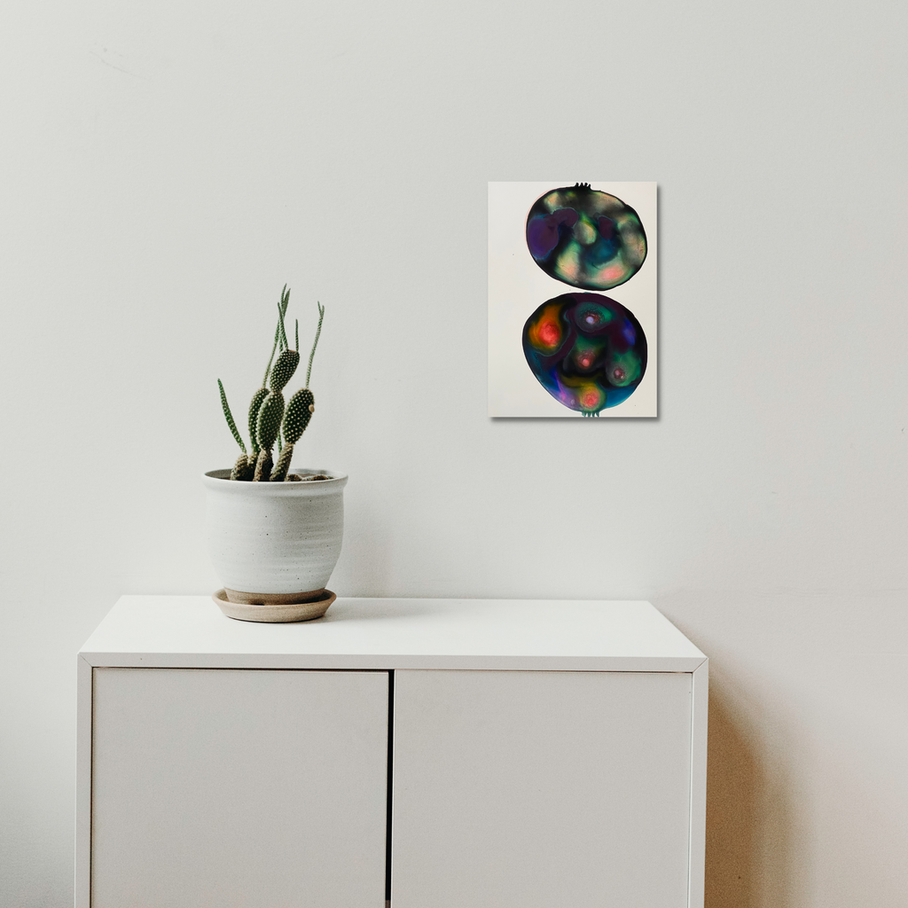 The artwork 'Galactic Pomegranate' by Arielle Stein features two circular orbs rendered in ink on white paper. Each sphere displays vibrant swirls of iridescent purples, greens, and deep oranges, creating a cosmic, nebula-like effect. The abstract composition evokes celestial bodies or cross-sections of pomegranates floating in space, measuring 12x9 inches.
