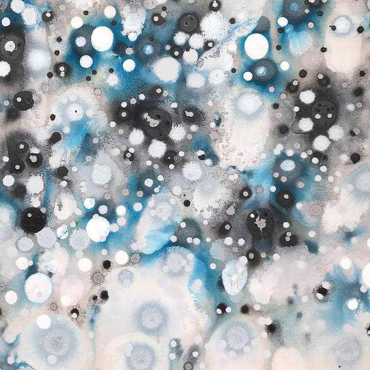 The artwork 'Glacial Galaxies' by Eric Jiaju Lee features a mesmerizing abstract composition of floating circular forms in white, turquoise blue, and charcoal gray. The ethereal pattern resembles a cosmic nebula, with luminous orbs scattered across a misty background. The acrylic painting creates depth through layered translucent effects and dynamic light-dark contrasts. 46x46 inches by Eric Jiaju Lee.