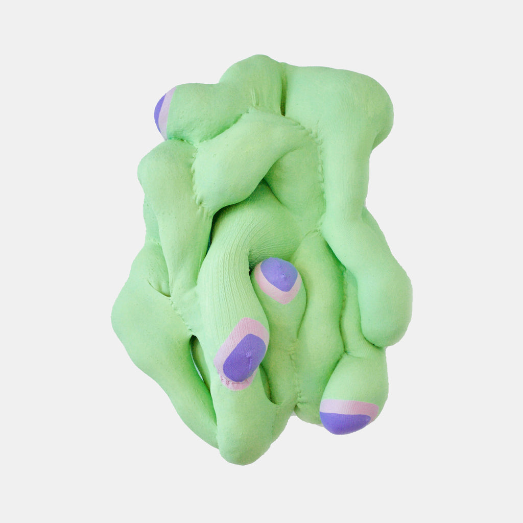 The artwork 'Green Tangle' by Hanna Washburn features a sculptural textile piece in mint green with purple accents. The abstract form shows intertwining, organic shapes creating a bulbous, cloud-like structure made from recycled fabrics. The soft, padded texture suggests depth and dimension, with curved lines and rounded edges throughout the composition. Purple oval details punctuate the flowing green form.