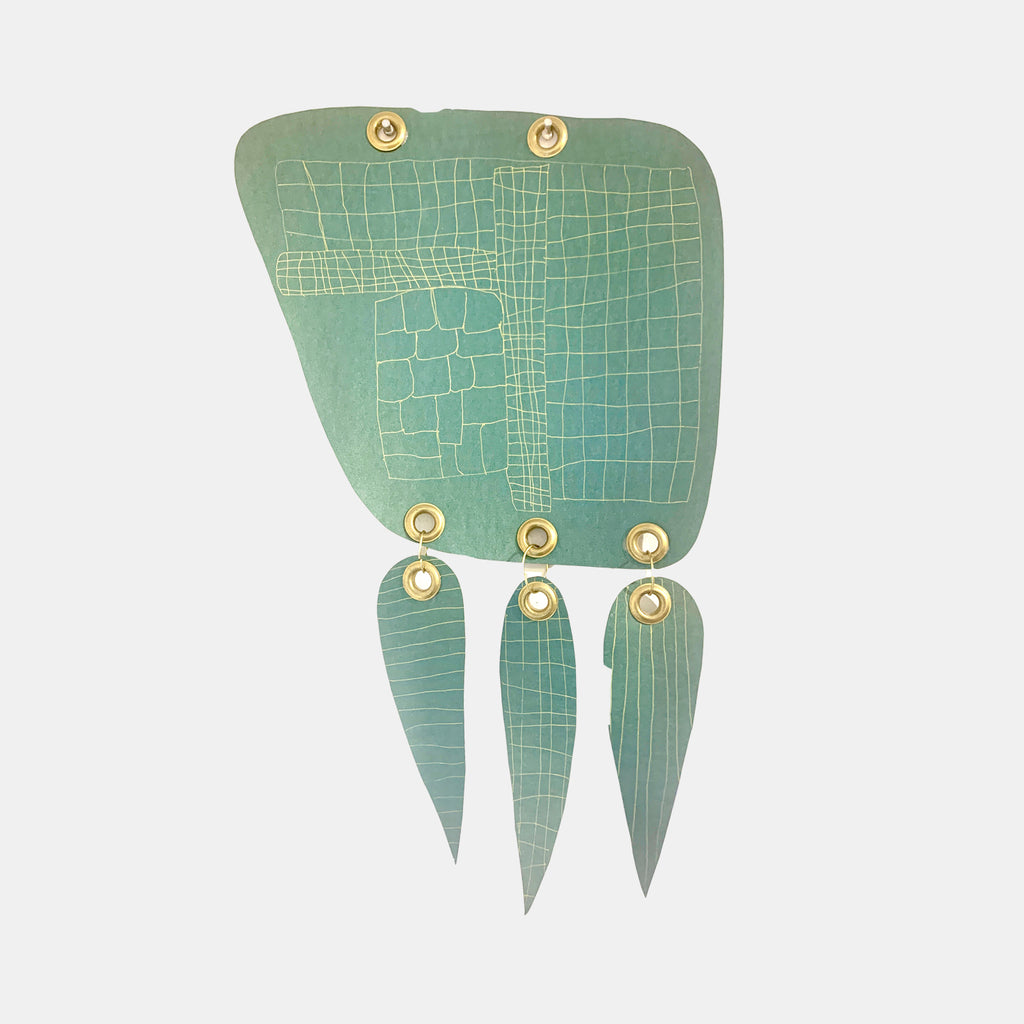 The artwork 'Griddish' by Sunny Chapman features a sage green metallic paper composition with geometric grid patterns and three teardrop-shaped pendants. The main piece displays intricate hand-drawn gel pen lines forming irregular grid cells, while brass grommets add industrial detail. The artwork measures 20x12 inches on premium metallic paper stock.