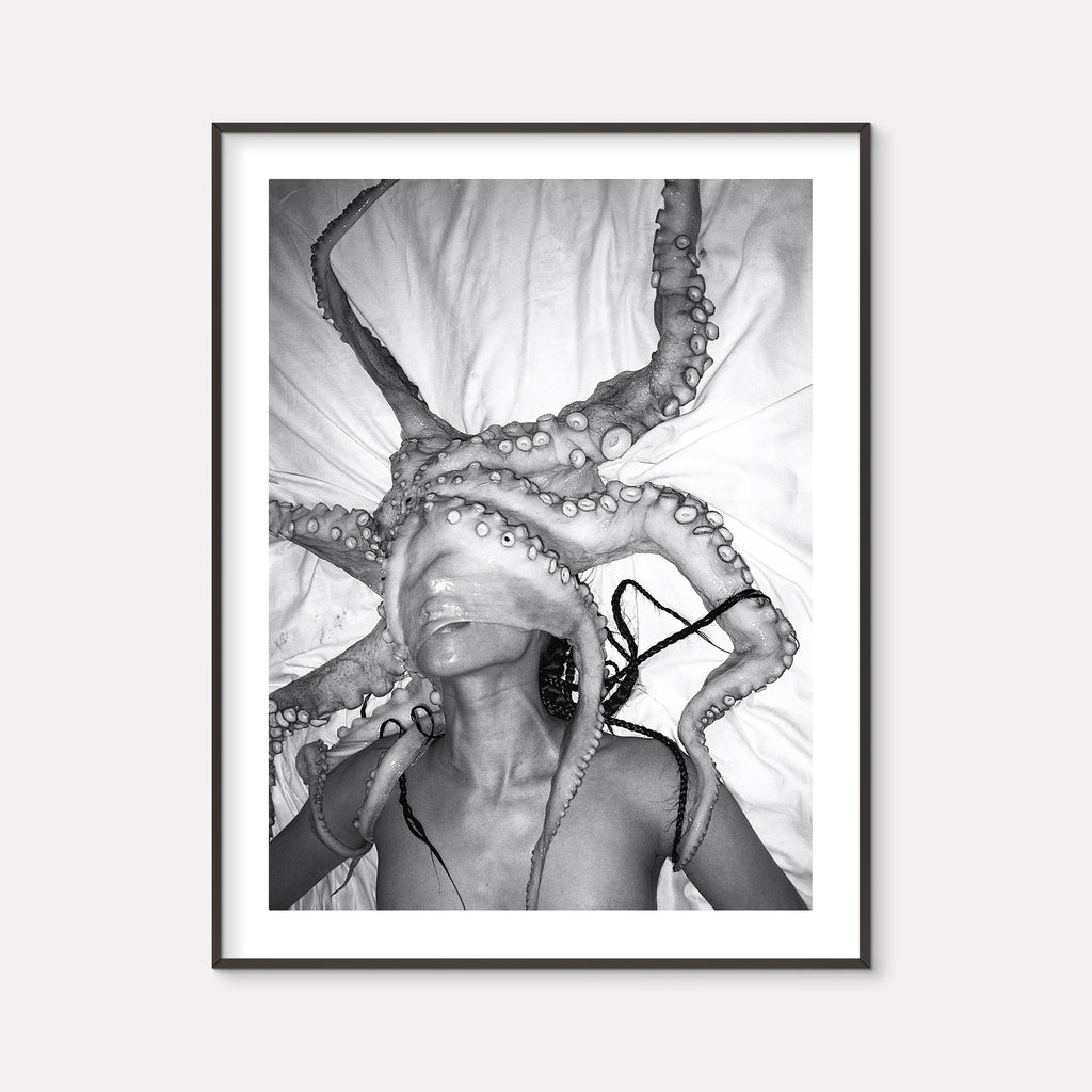 The artwork 'HOSHIKUZU' by Mari Sarai features a dramatic black and white composition with an octopus tentacle creating bold, curving lines against a light background. The tentacles display intricate textural details with distinctive suction cups, cast in high contrast monochromatic tones. Printed on premium Hahnemuhle paper, creating a striking fine art aesthetic. By Mari Sarai.