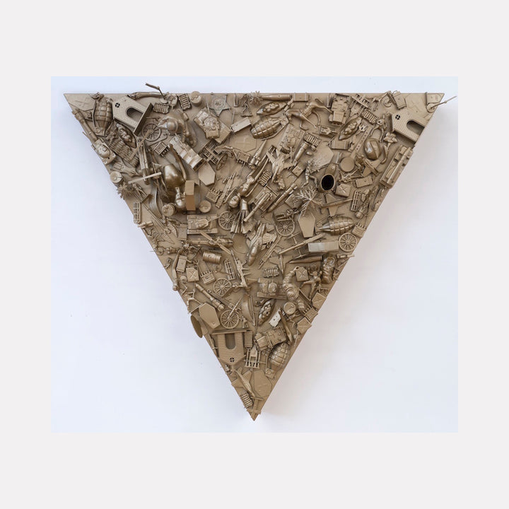 The artwork 'Holy Wars' by Margaret Roleke features a triangular wall relief composed of densely packed toy weapons and military objects painted in monochromatic beige. The assemblage creates a textured collage effect against a wooden construction, measuring 31x31 inches. The found objects overlap and intersect, forming a commentary on conflict through children's playthings.