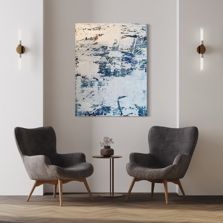 The artwork 'How to rewrite your childhood in five easy steps' by Roger Hsia features an abstract composition with textured layers of white and blue acrylic paint. The canvas displays a weathered, distressed appearance with dynamic brushstrokes creating a sense of movement and depth. The cool-toned palette evokes a wintry, ethereal atmosphere across the 48x36 inch surface.